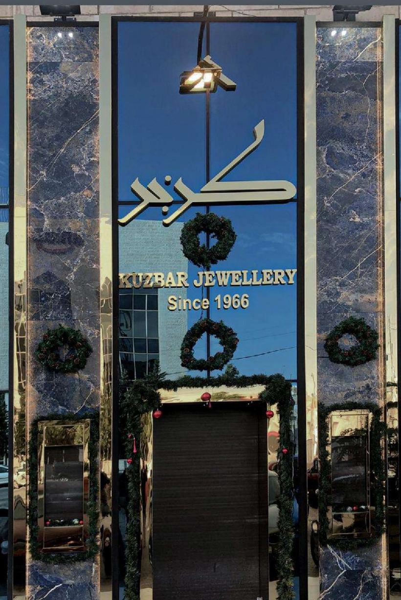 Kuzbar Jewellery vertical façade in lapis-veined marble and brass calligraphy, Amman